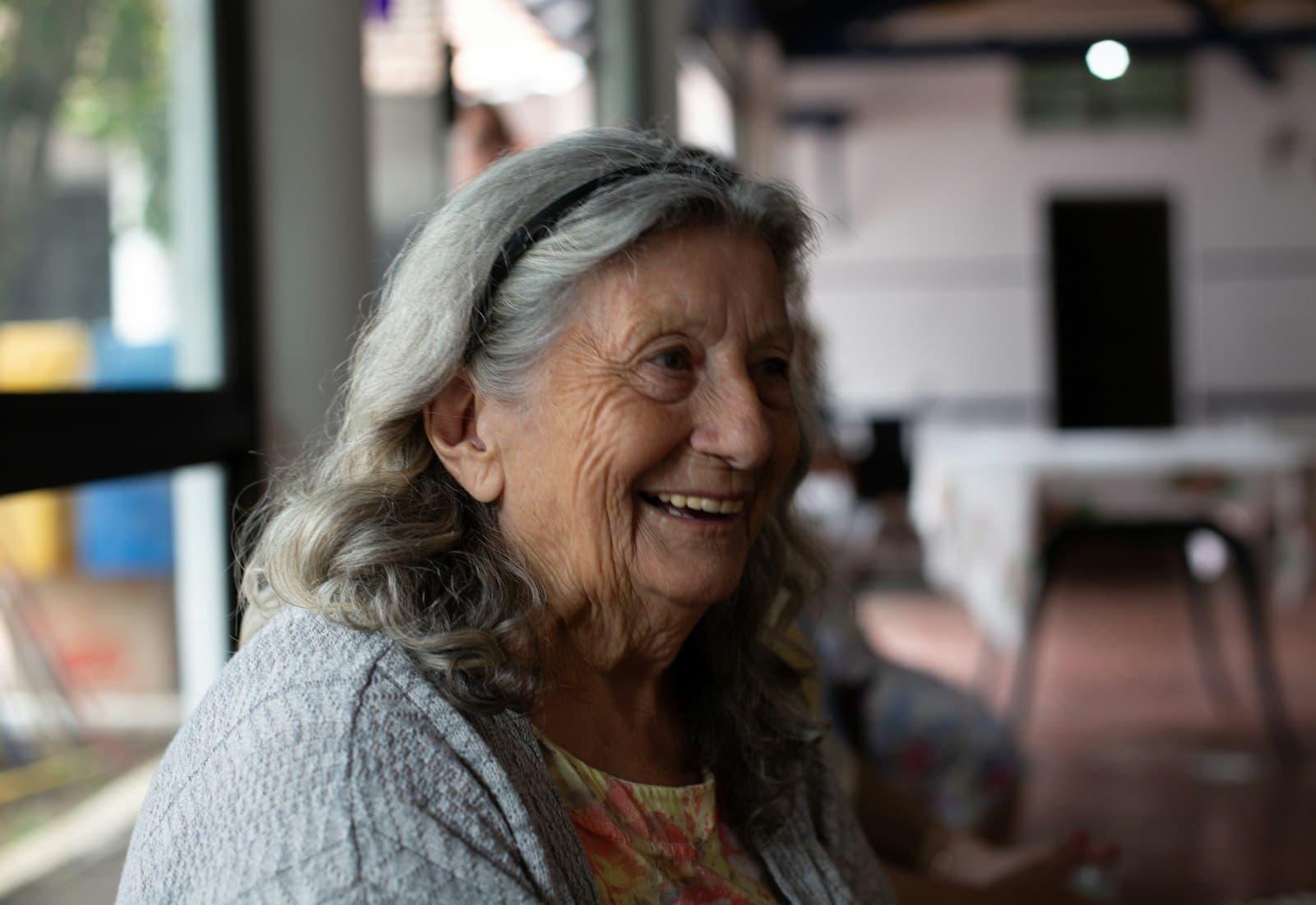 A smiling older woman in a community lounge